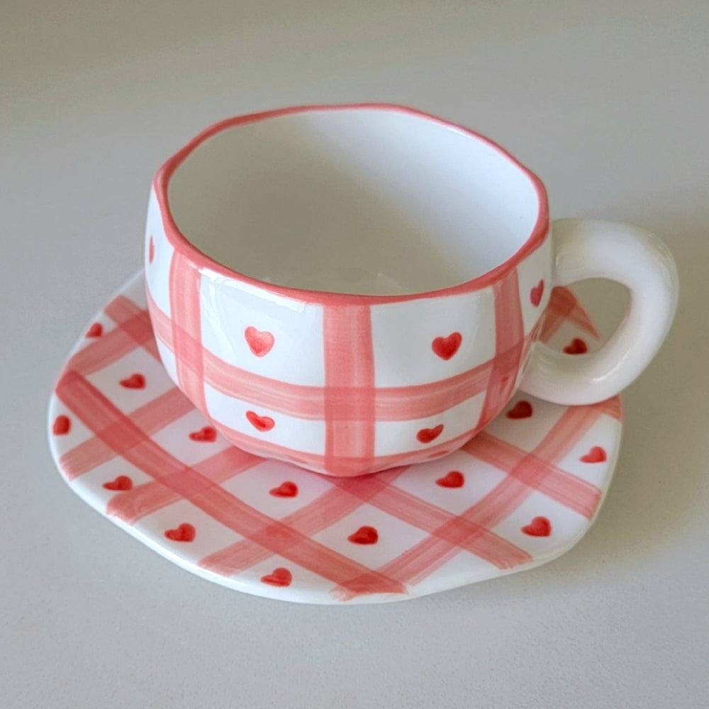 Cup and saucer with pink checkered design