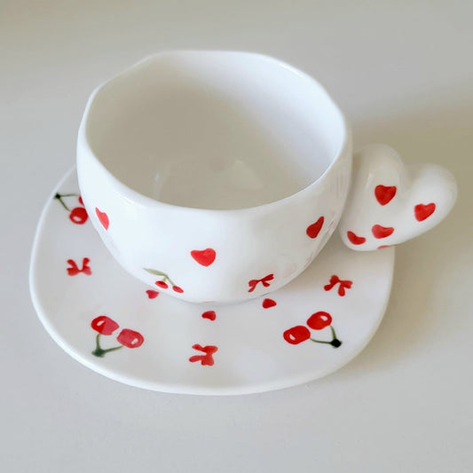 White teacup and saucer with red heart & cherry designs