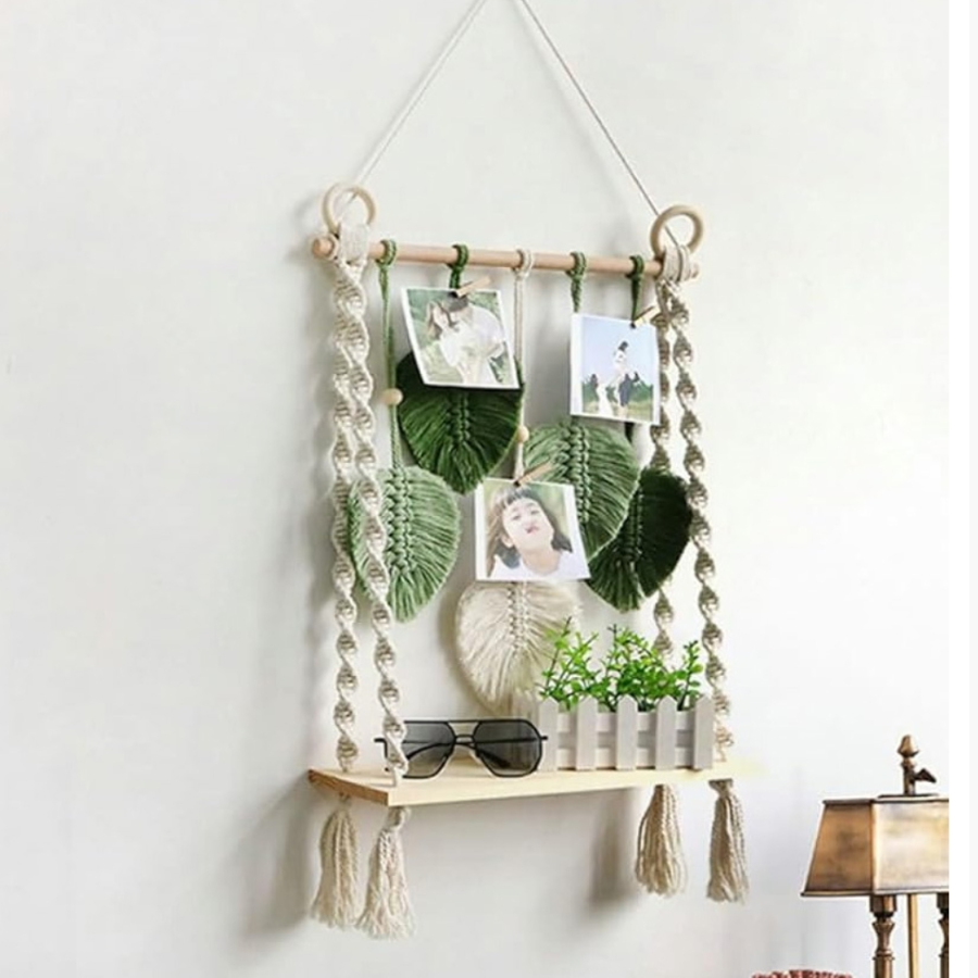 Macrame wall hanging with shelves and decorative items on a white wall.