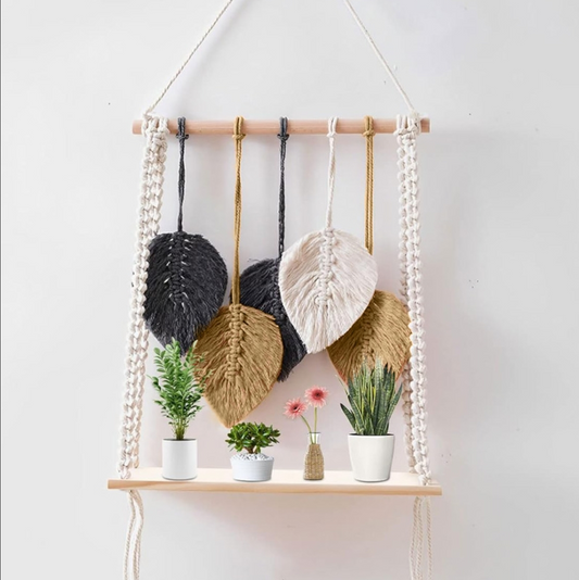 Macrame wall hanging with plants on a white background