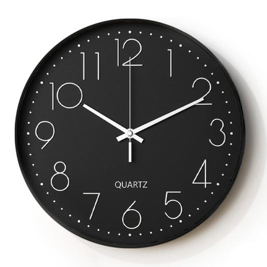 Black wall clock with white numbers and hands on a white background